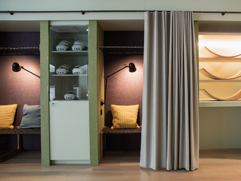 Innenarchitektur von Atelier Türke für das LMZ mit gemütlich gestaltetem Rückzugs- und Sitzbereich mit integrierten Nischen und Vorhang.