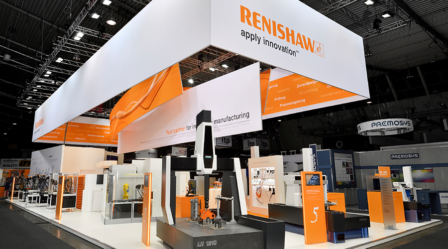 Messestand von Renishaw, entworfen und gebaut von Atelier Türke, in Orange und Weiß mit Maschinenexponaten und großflächiger Markenkommunikation in einer Messehalle.