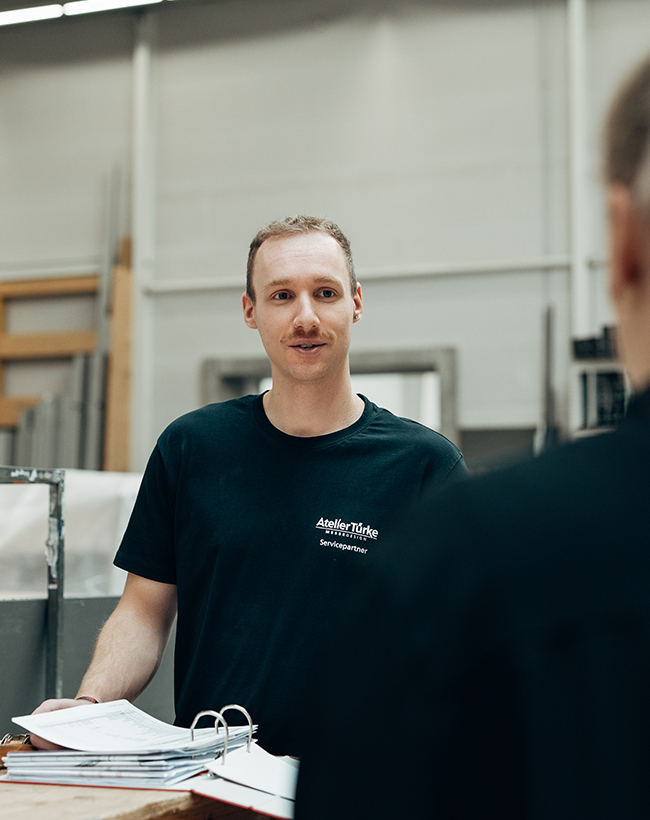 Dominik Schwenger, Mitarbeiter im Lager bei Atelier Türke, im Gespräch im Lager