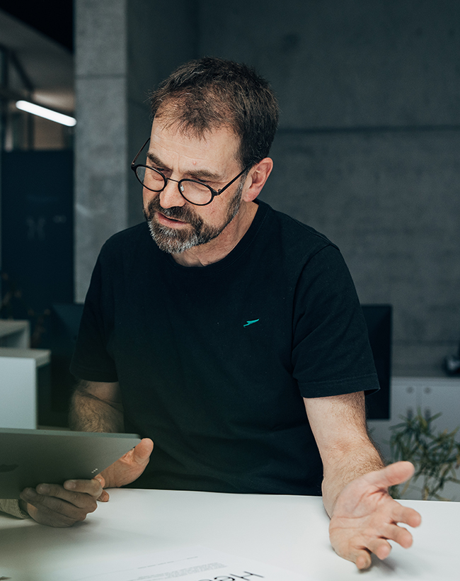 Gerd Klopfer, Designer für Branding, Print, Digital und Motion bei Atelier Türke, im Gespräch vor einem Tablet