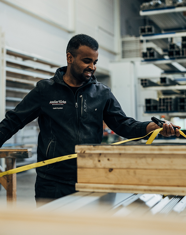 Kalid Hussien, Mitarbeiter im Lager bei Atelier Türke, beim Fixieren von Transportmaterial
