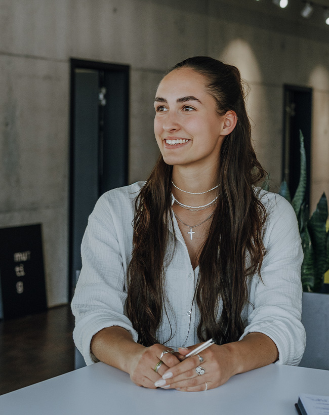 Katharina Mayer, Innenarchitektin für Raumkonzeption bei Atelier Türke, in einem Gespräch mit Kollegen im Büroflur.