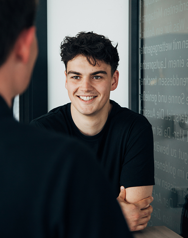 Lasse Pekdag, Assistent der Geschäftsführung bei Atelier Türke, im Gespräch an einem Stehtisch