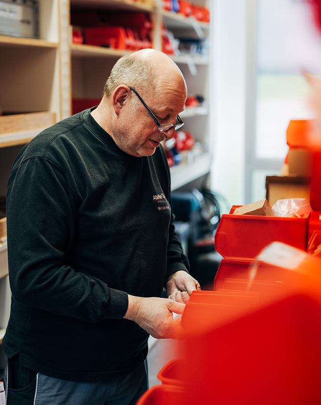 Michael Oswald, Leiter im Lager und Individualbau bei Atelier Türke, beim Einsortieren von Materialien im Werkstattbereich