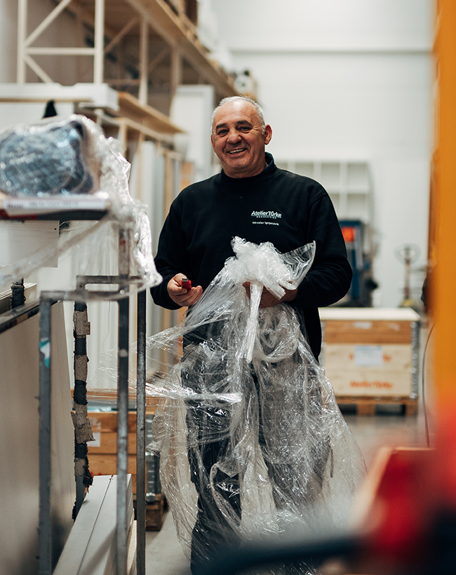 Miroslav Ignjatovic, Mitarbeiter im Lager und in der Montage bei Atelier Türke, bei der Arbeit mit Verpacksmaterial