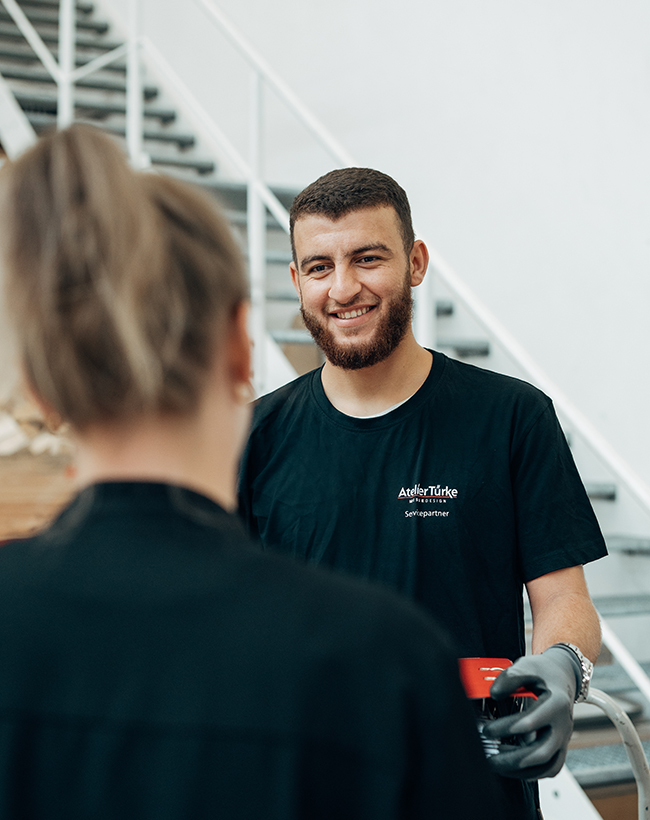Mohammed Noor Dandal, Mitarbeiter im Lager bei Atelier Türke, im Gespräch mit einer Kollegin