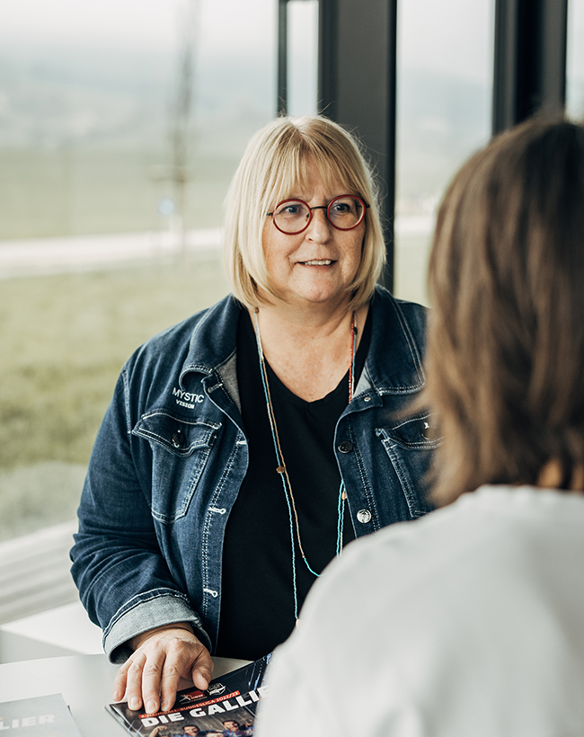 Sabine Türke, Geschäftsleitung für Finanzen und Controlling bei Atelier Türke, im Gespräch mit einer Kollegin im Büroflur