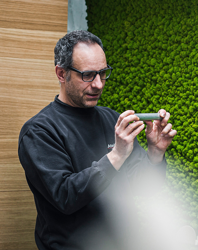 Volker Meyer, Projektkoordinator und stellvertretender Lagerleiter bei Atelier Türke, bei der Begutachtung eines Musters vor einer Moos-Wand